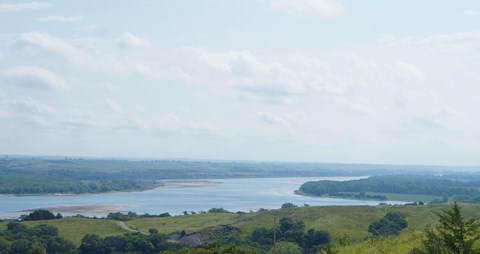 Overlooking the Missouri River containing sandbars and trees along the banks. The river bends right.