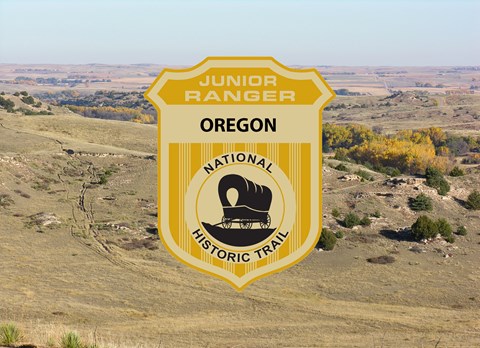 A junior ranger badge on an image of a sweeping hillside.