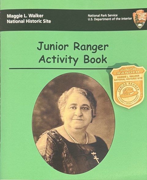 Cover of green and black booklet with a wooden badge on top