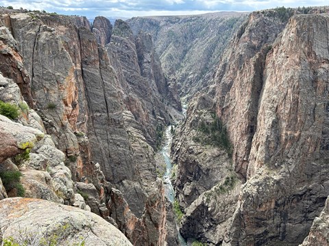 A steep canyon with vertical walls and a river at the bottom