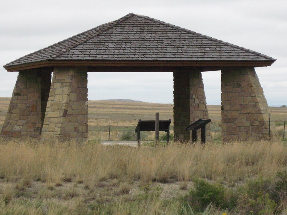Stone pillared kiosk with information panels and a wood roof