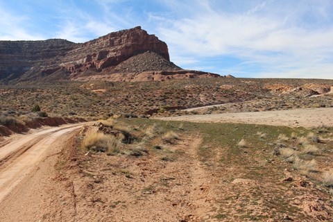 A dirt road with large sandstone boulder