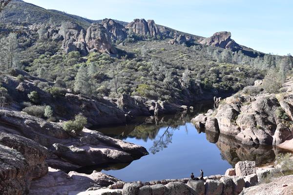 A view of the reservoir filled with water, surrounded by jagged rock formations on all sides.