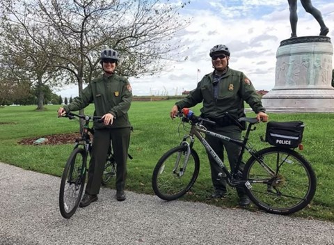 Two rangers on bikes with helmets on.