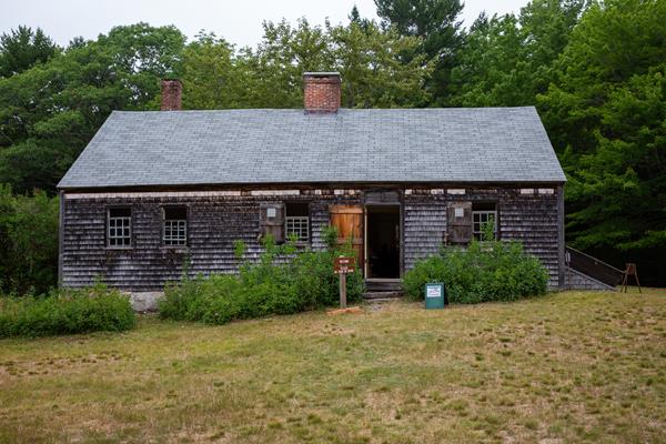 Wooden structure with two chimneys surrounded by a yard