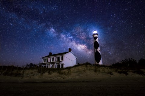 The Milky Way arches across the night sky above the Cape Lookout Lighthouse and Keepers' Quarters
