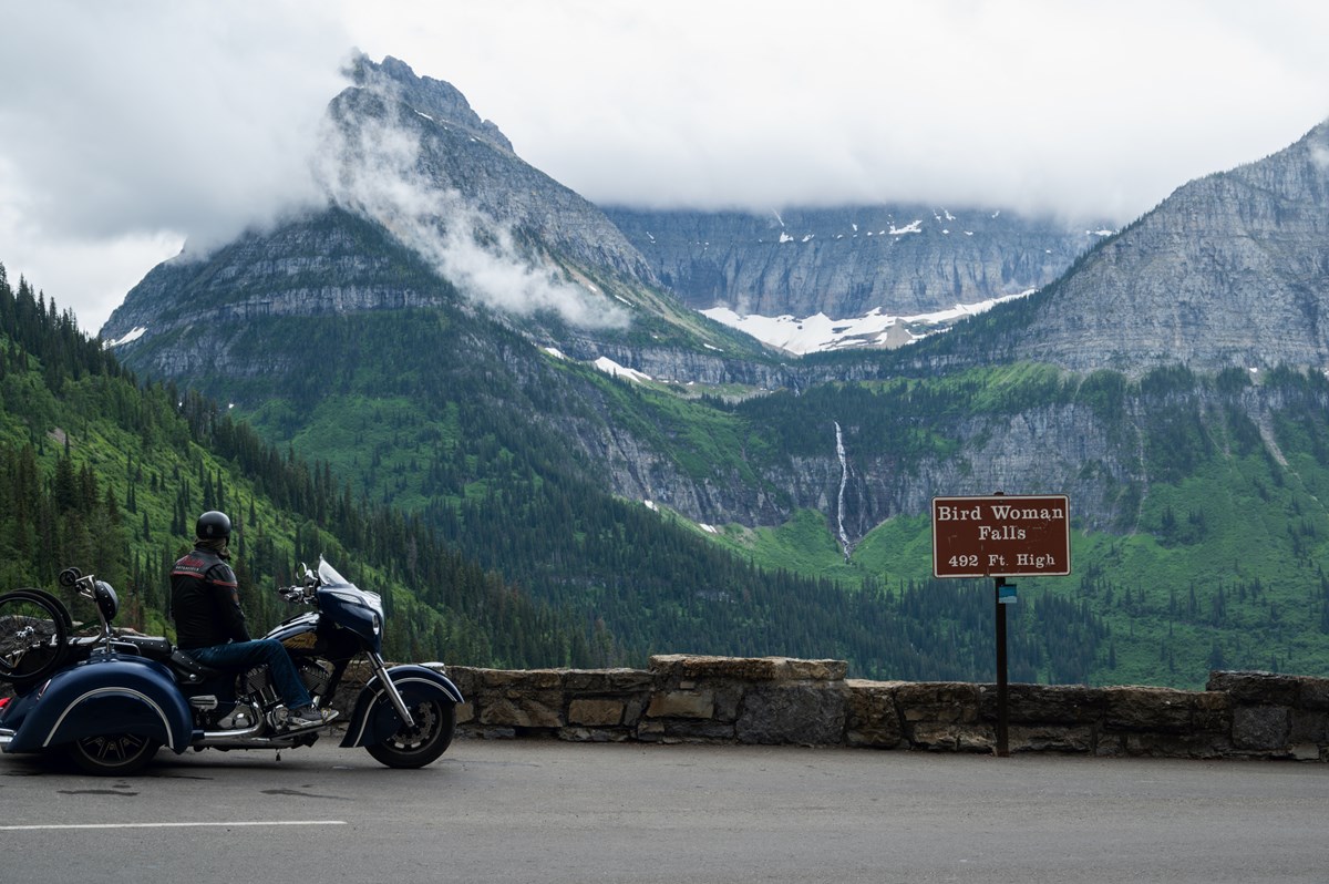 A motorcyclist marvels at the view from Bird Woman Falls Overlook
