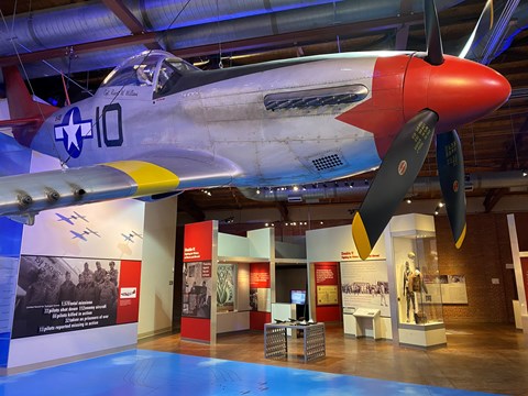 Replica P-51 hanging in front of various museum exhibits.