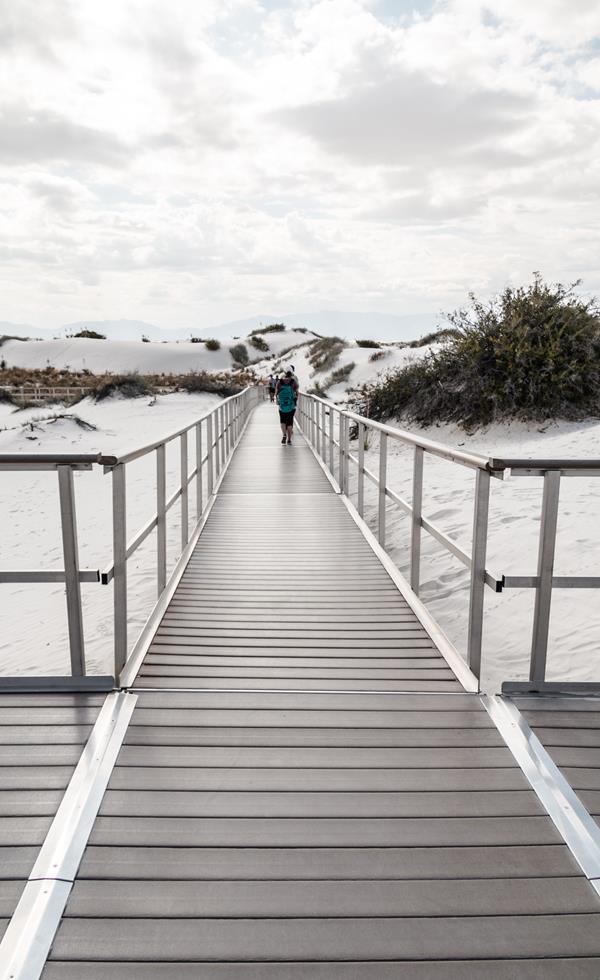A visitor walking down the Interdune Boardwalk.