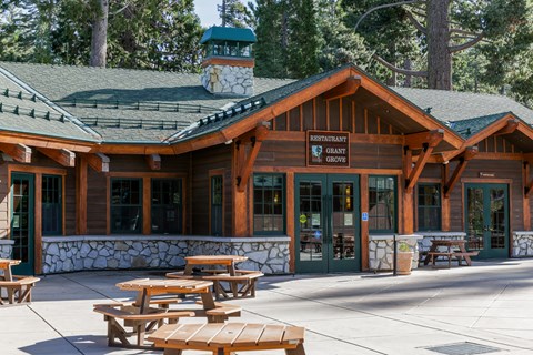 Wood-and-stone Grant Grove Restaurant building with outdoor picnic tables