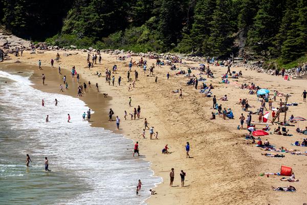 People relax and swim on a sandy beach