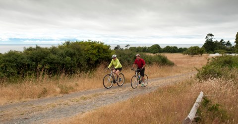 Two bikers traveling on a dirt road