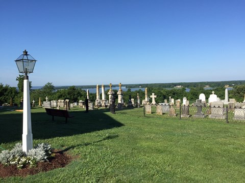 view from a bluff with a cemetery in the foreground and with a creek and forest in the distance