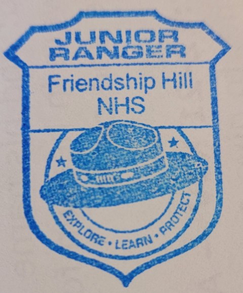 Badge shaped stamp reading Junior Ranger Friendship Hill NHS