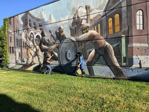 A mural showing Pullman factory workers and Pullman cars
