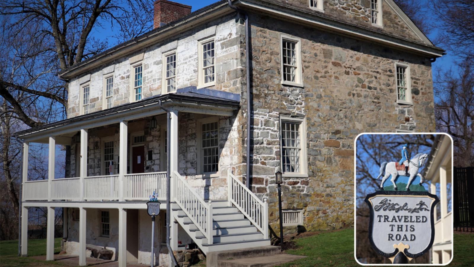 Historic stone house with a porch and a historical marker inset depicting a rider on horseback.