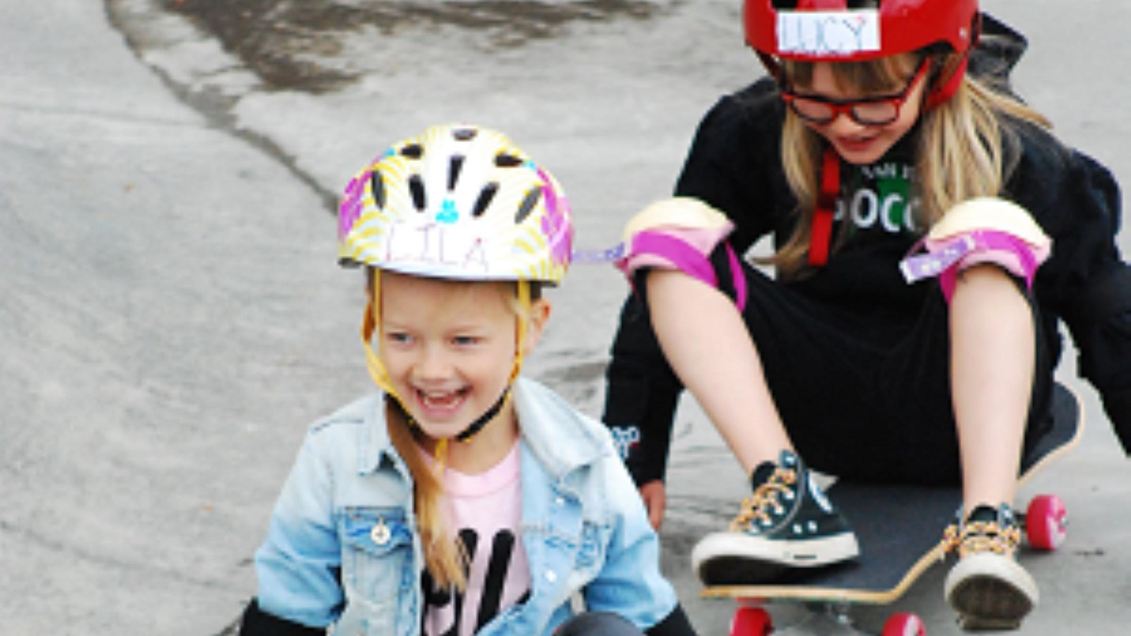 Photo of two young women using skateboards on concrete