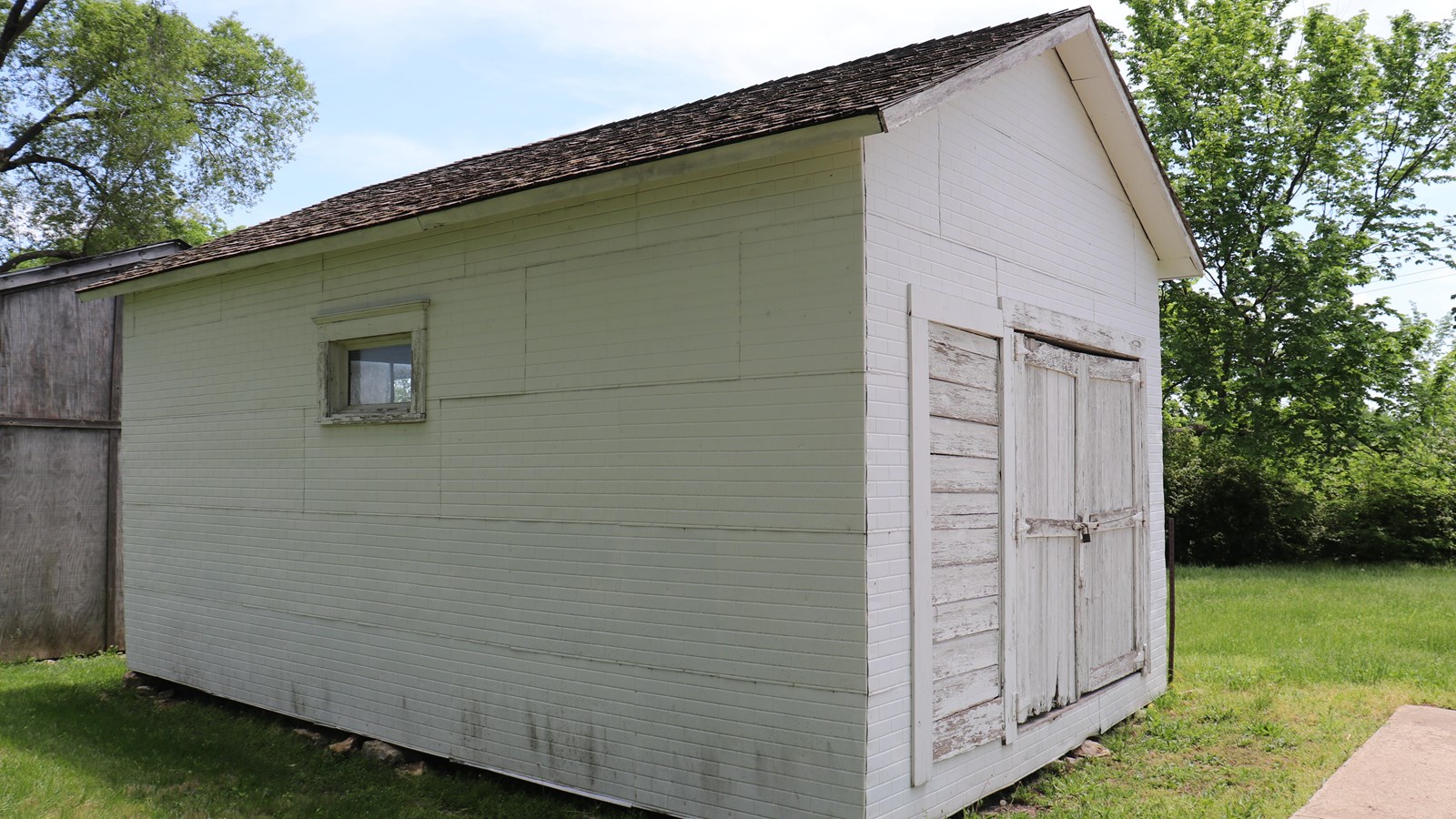 The rectangular white Truman garage with two doors on the front and a window on the side.