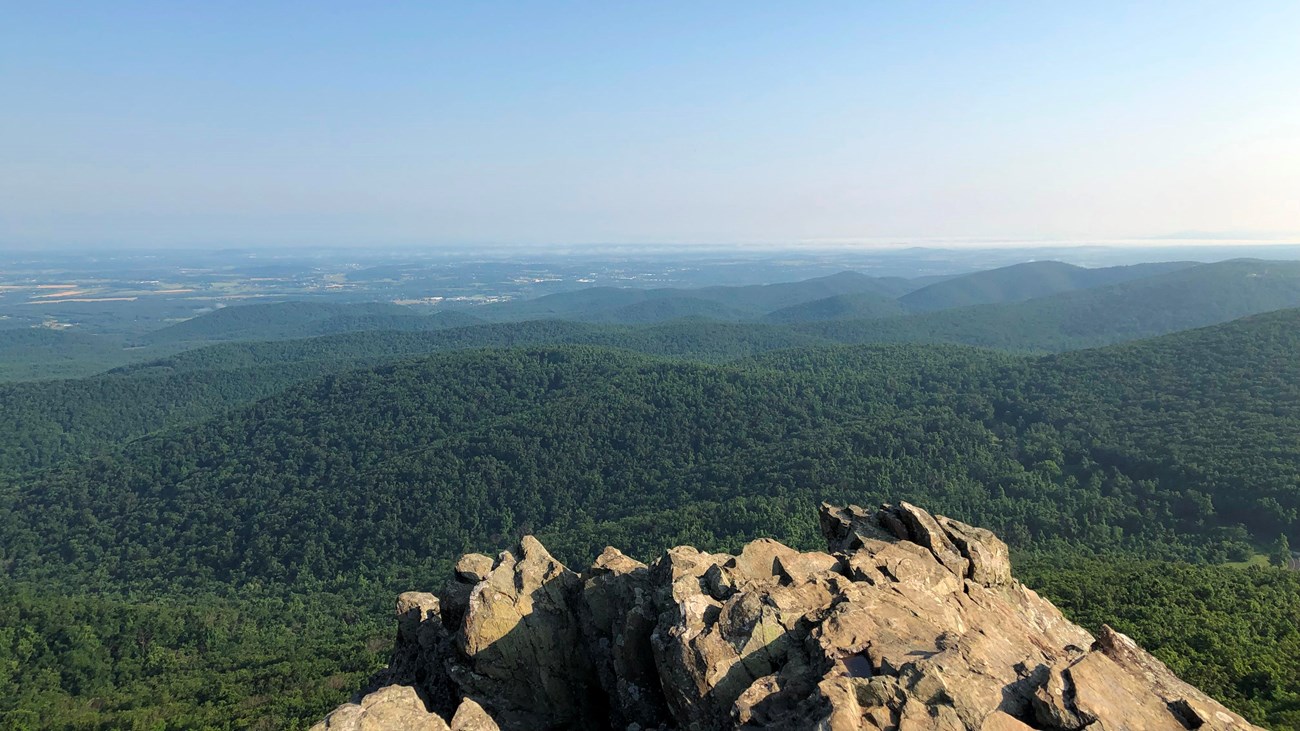 The view from Humpback Rocks shows the verdant Blue Ridge foothills fading into farmland.