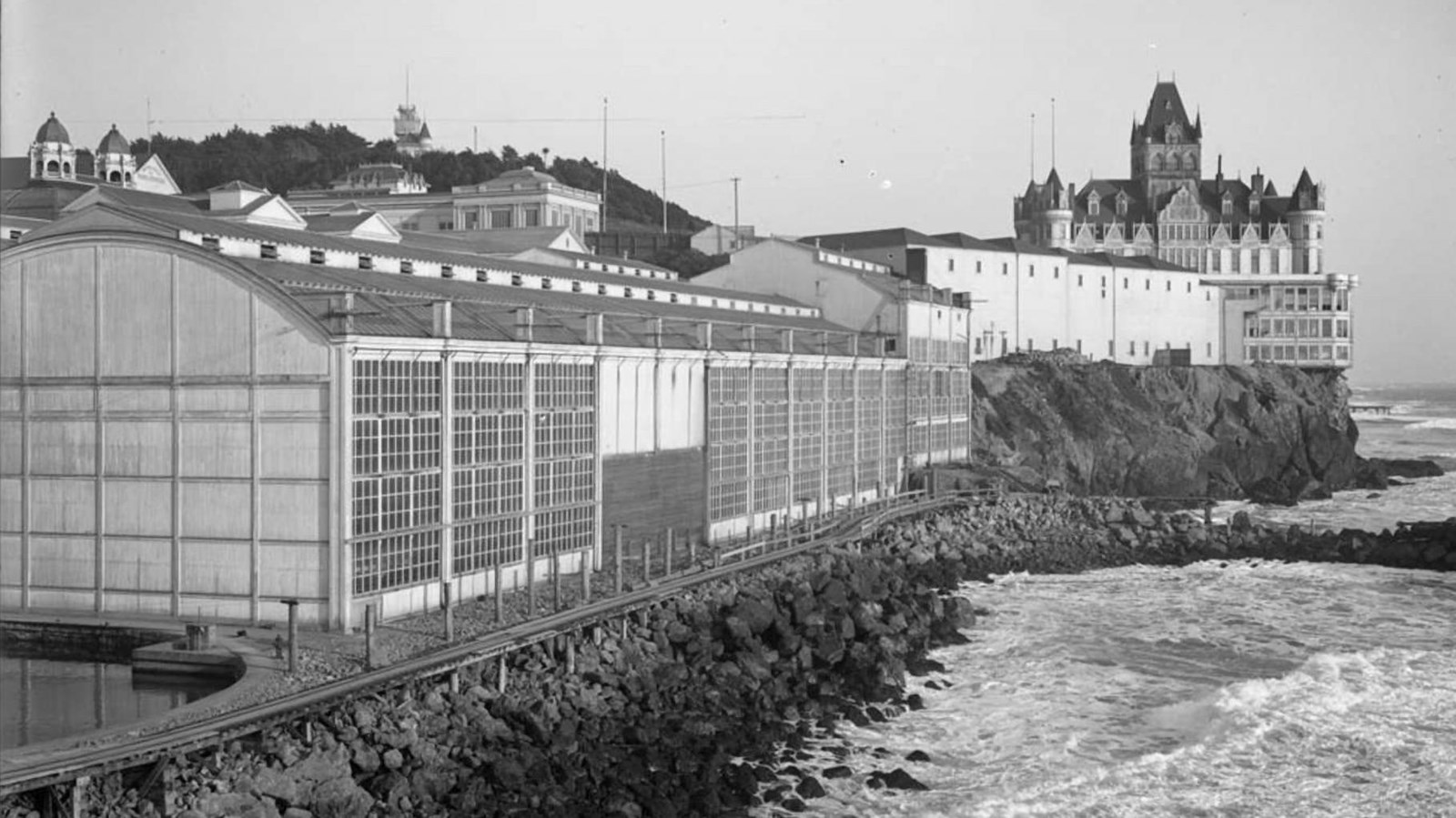 A view along the coast with Sutro Baths and Sutro\'s Cliff House beyond.