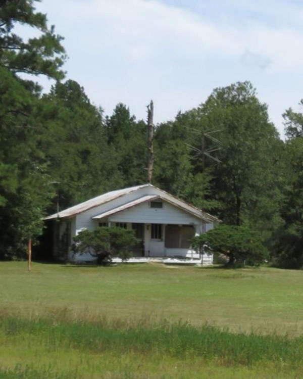 One white house and another building remnant are seen