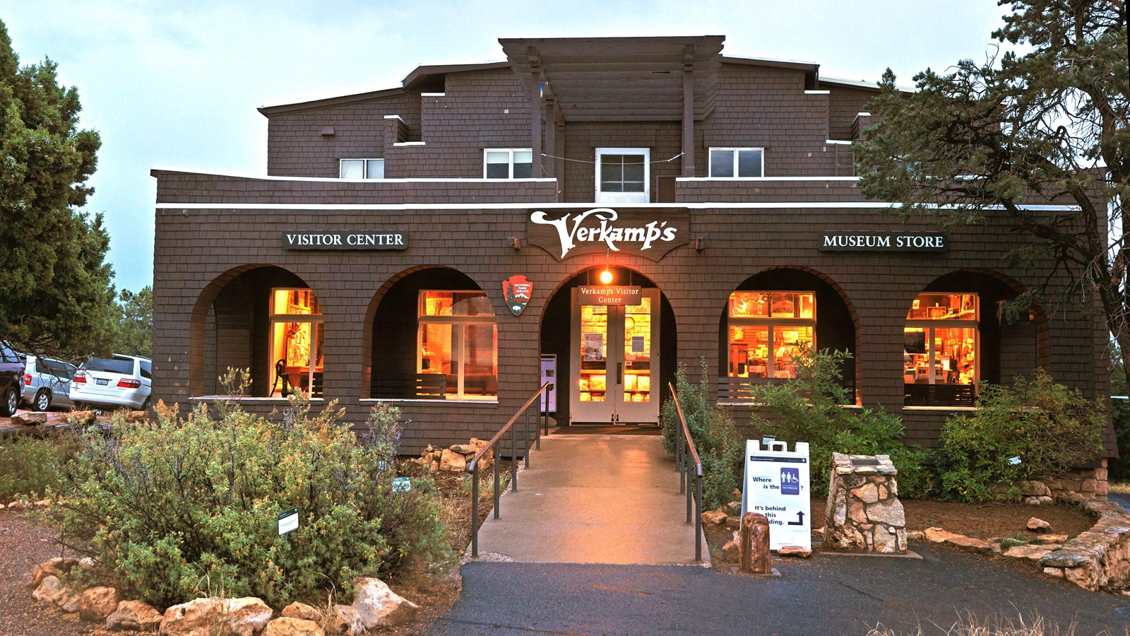 A two-story craftsman style building with the entrance in the center four large window within arches