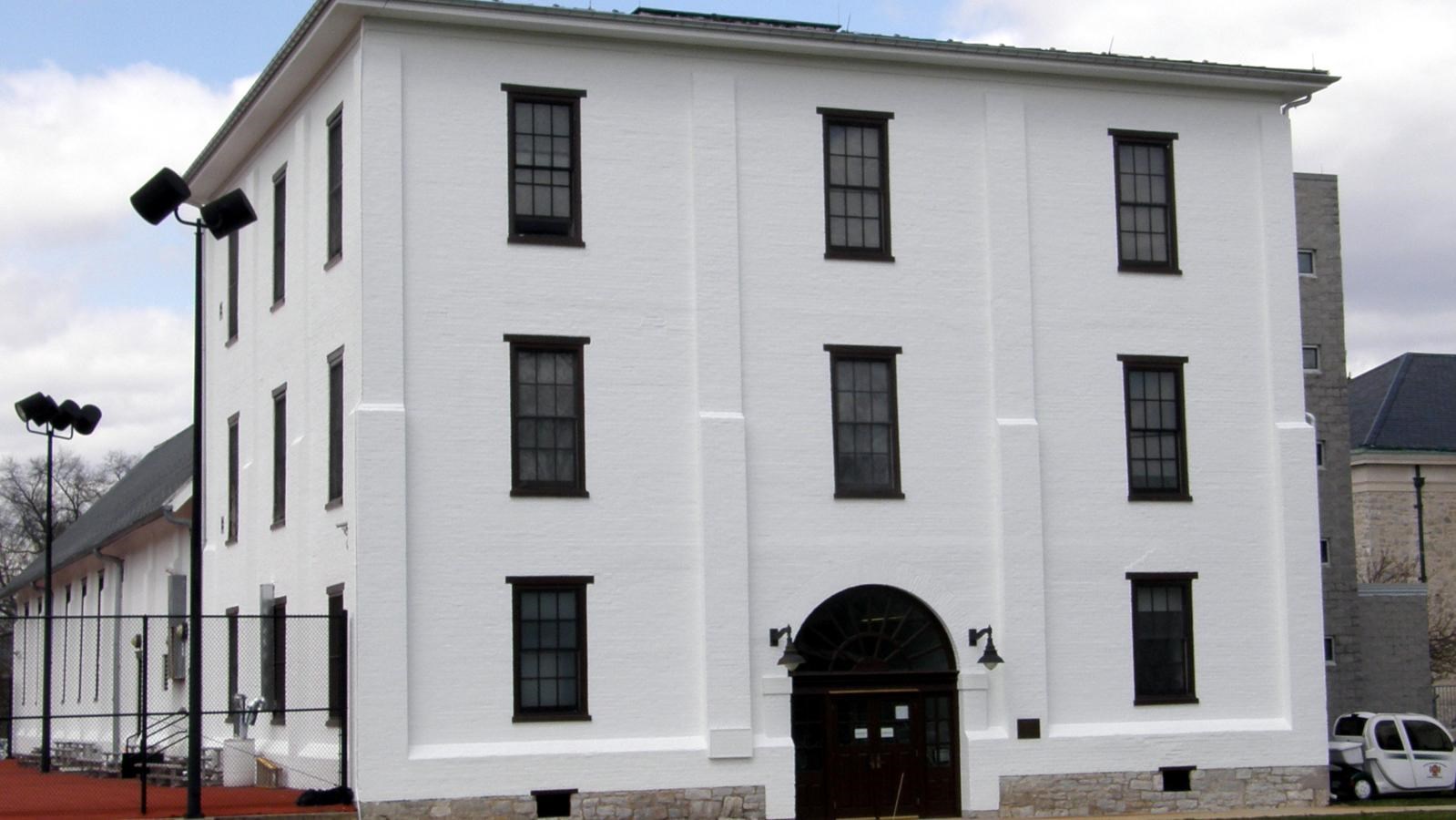 A white three-story building with a curved doorway.
