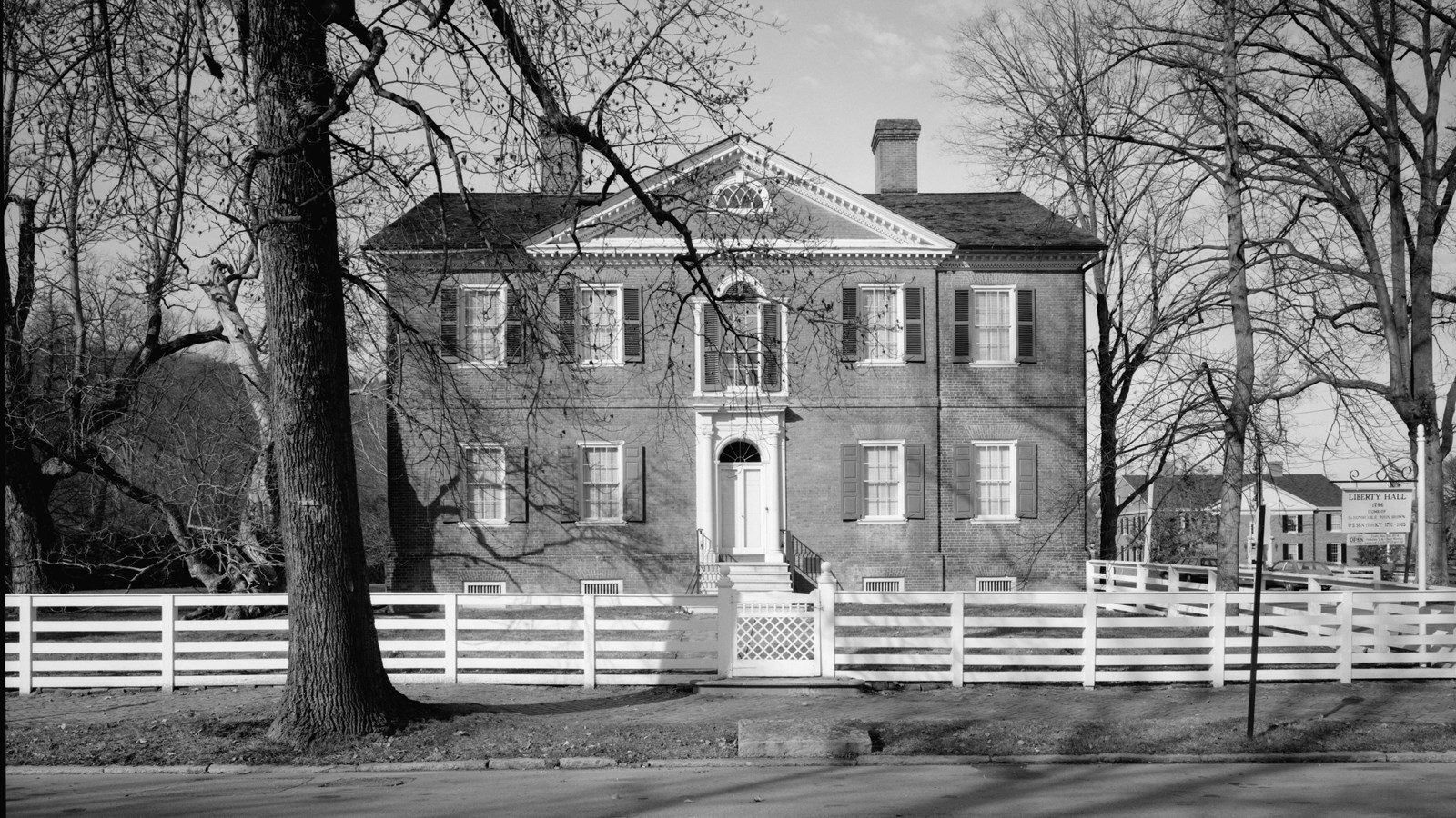 Two story brick house with four windows on the top and bottom floor