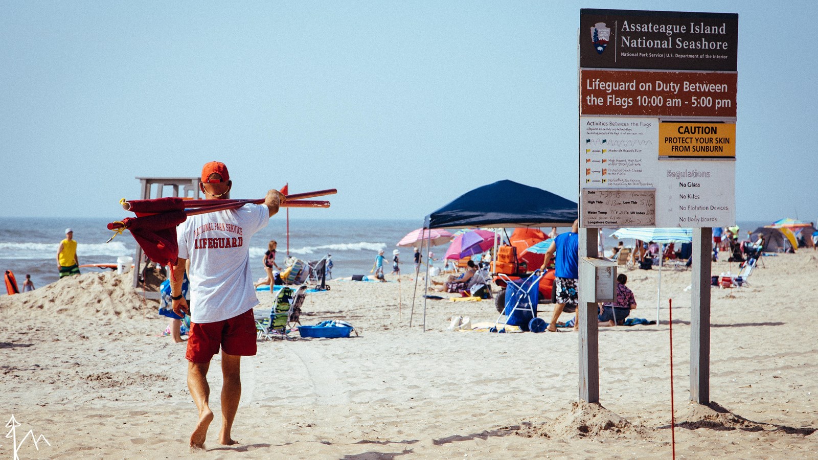 A lifeguard setting up the beach warning flags for the day