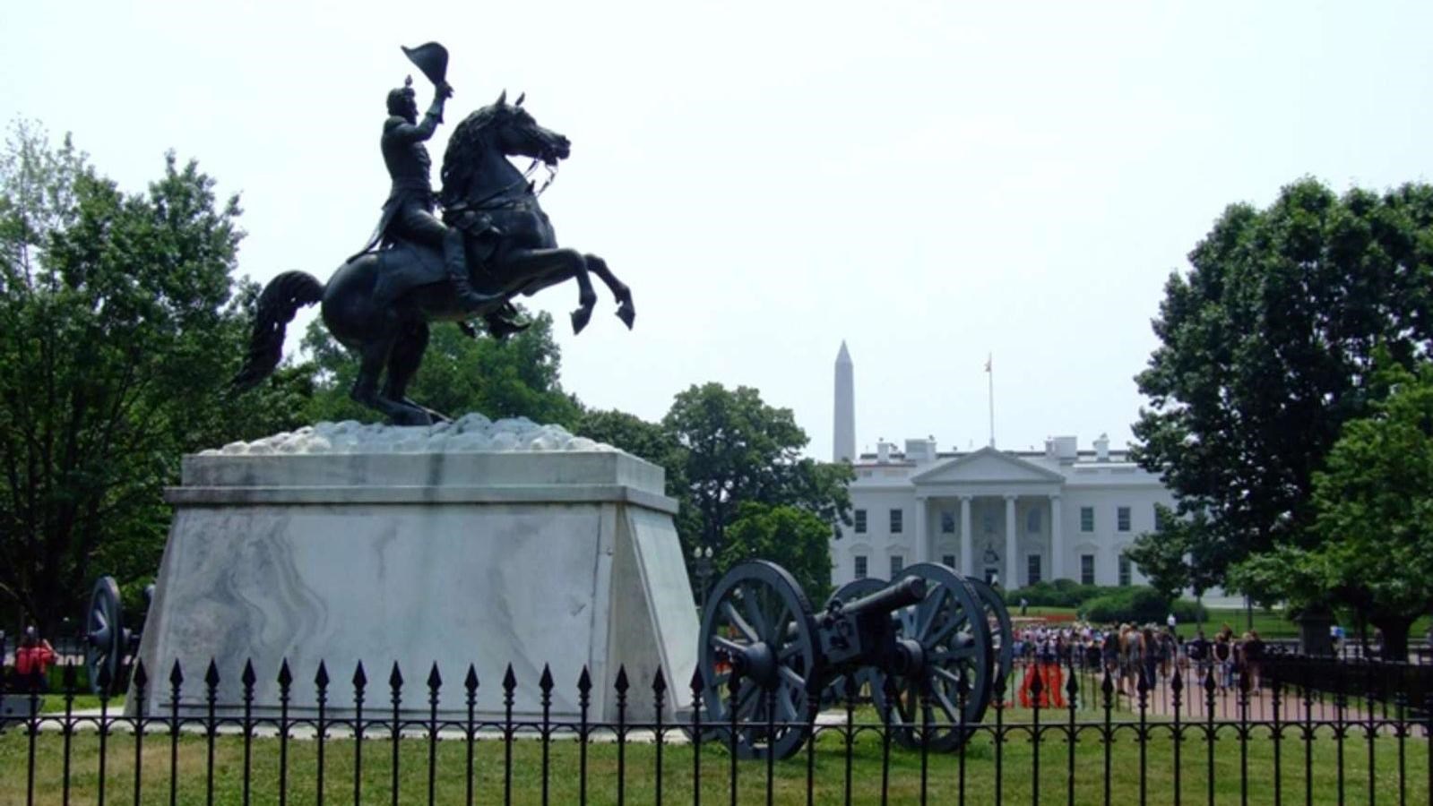 A statue of General Andrew Jackson on a galloping horse waving hat in the air. A canon is nearby.