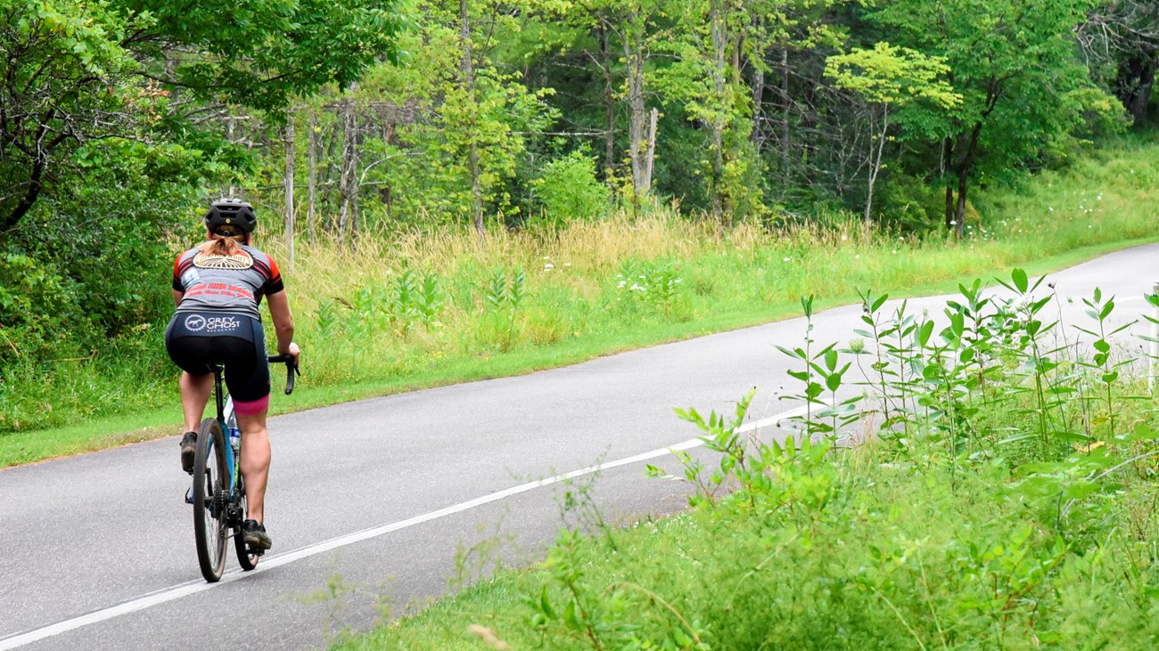 Single cyclist using the bike lane of a paved road while wearing proper safety gear