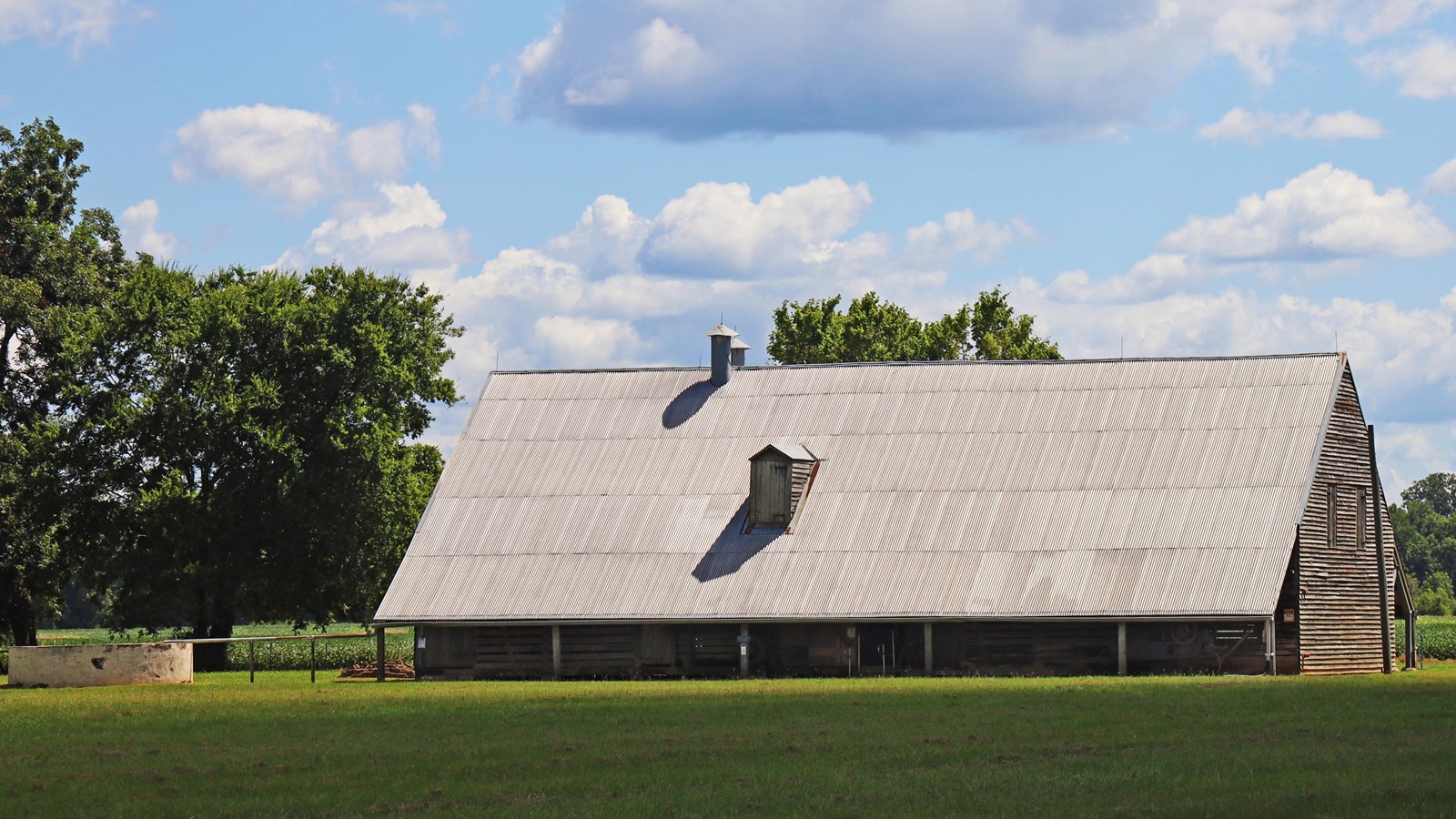 A large wood-framed barn with a metal roof.