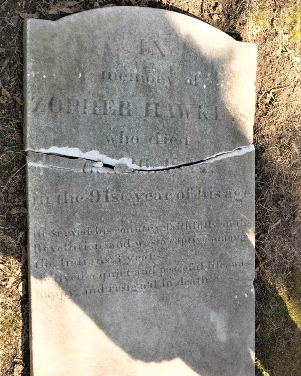 A fallen over, large flat tombstone with the name "Zopher Hawkins" inscribed at the top