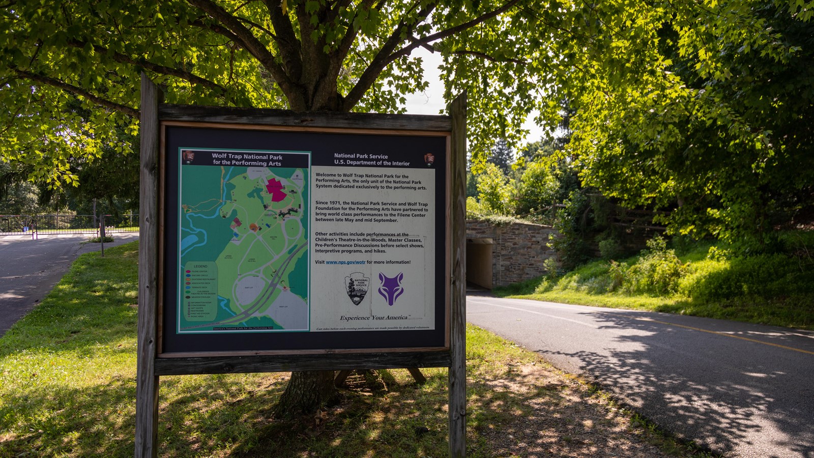 Information panel with map and general description of park, pathway into tunnel in background