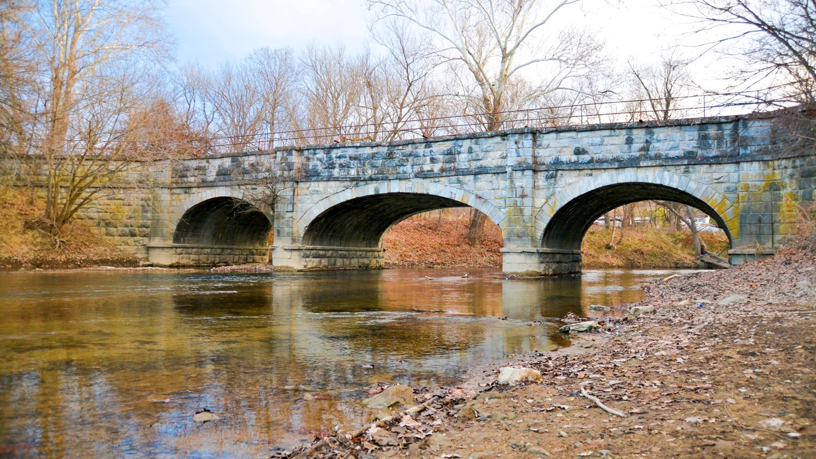 A three arch aqueduct spans the canal