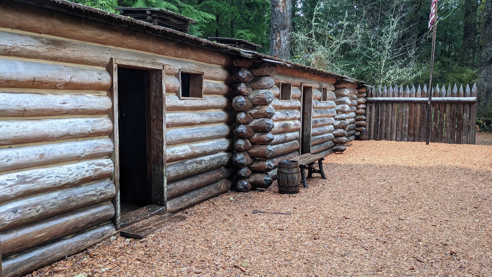 Three doorways enter into dark rooms of a 50 foot long log fort