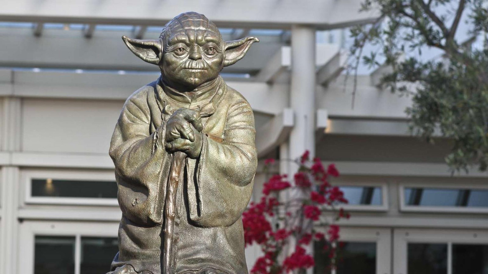 Statue/fountain of Star Wars character Yoda on courtyard.