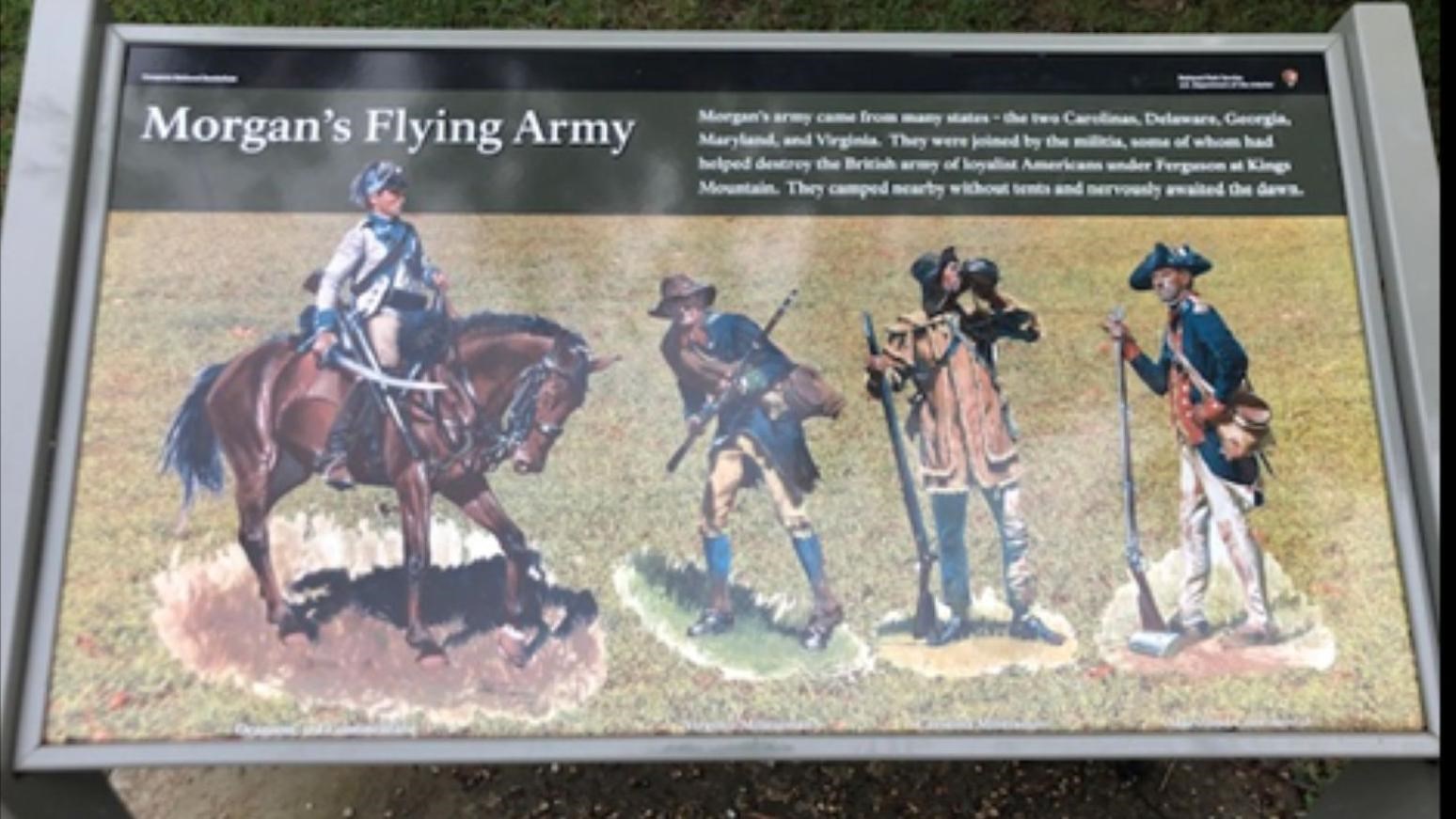 A sign with a soldier on a horse along with three other soldiers painted on it.