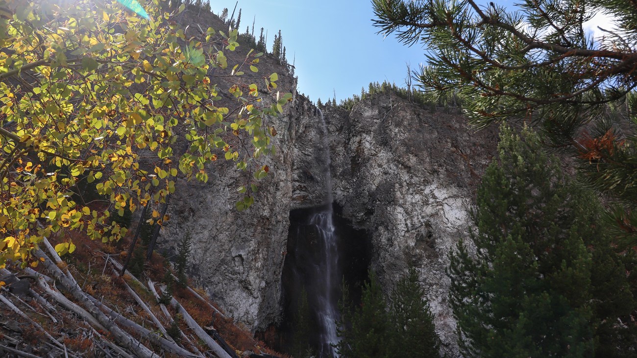 A thin waterfall cascades down a rocky cliff.