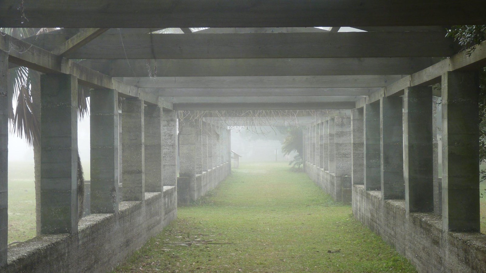Open-air pergola made of tabby in layers of fog.