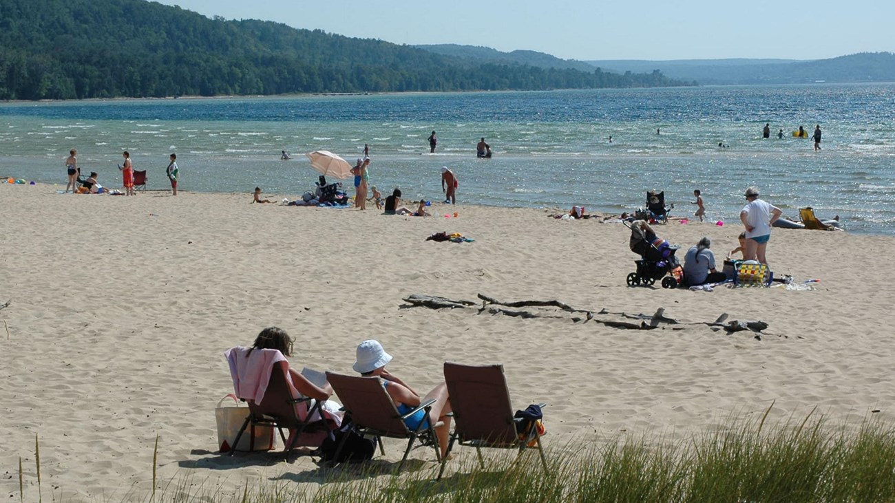 People on the beach and in the water at Sand Point Beach