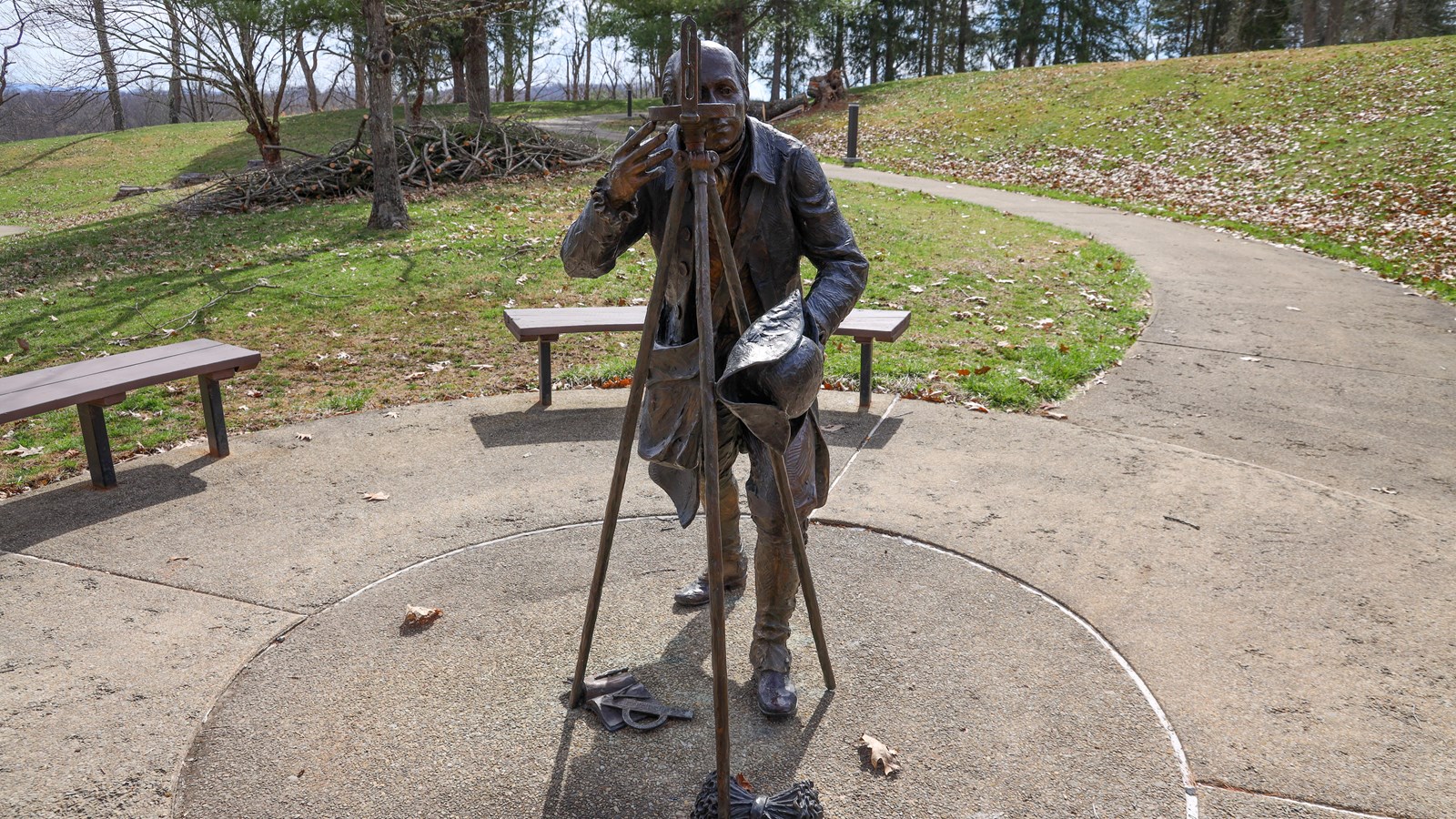 Albert Gallatin sculpture on a level concrete surface with benches circling the statue.