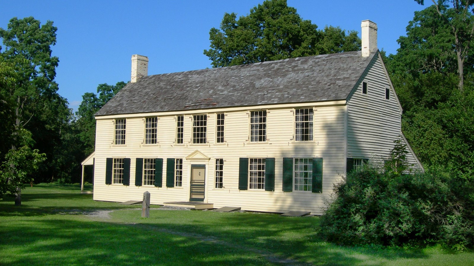 A large, yellow symmetrical house. 