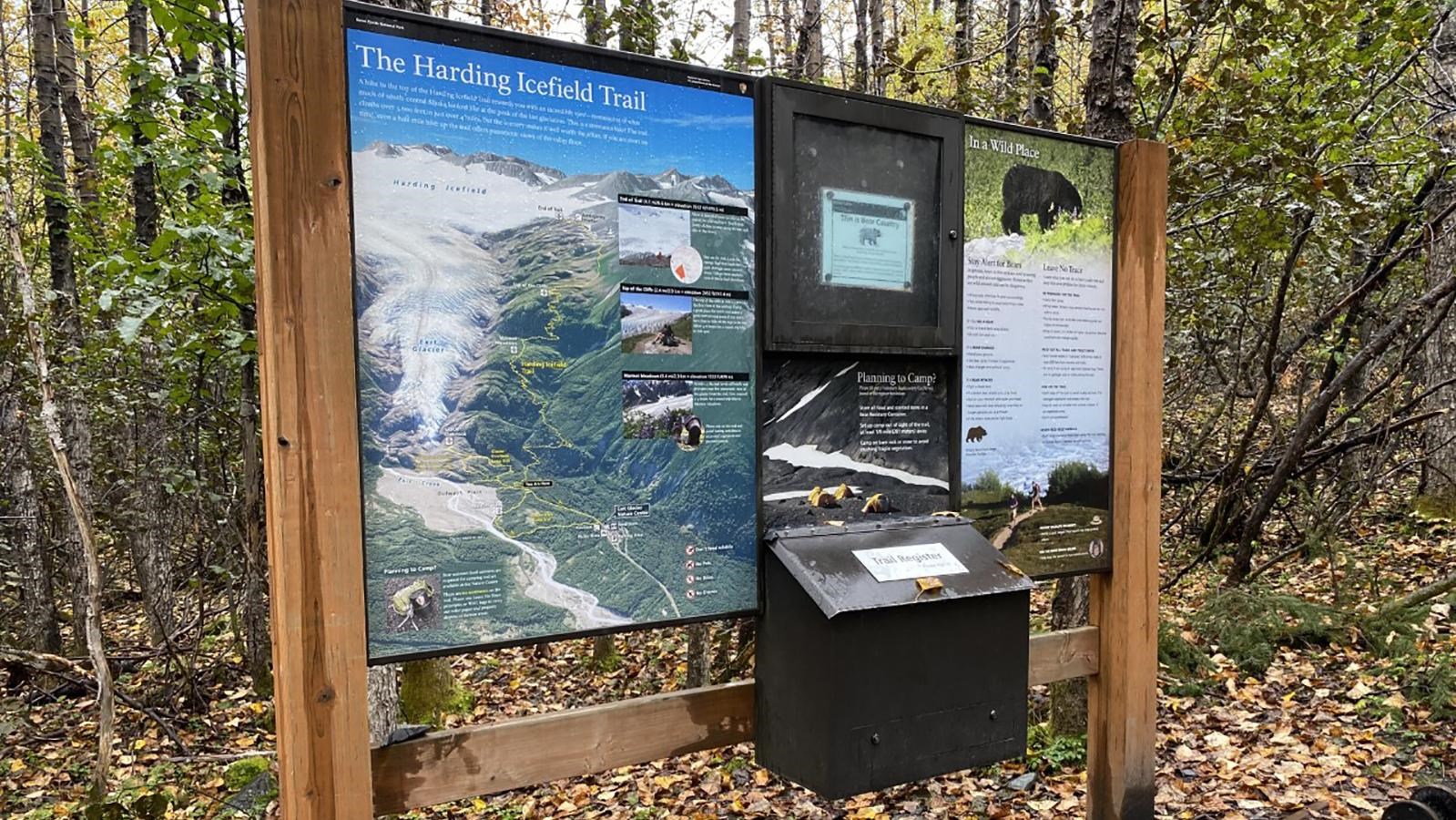 An information sign at the start of the Harding Icefield Trail.  A forest is behind the sign.