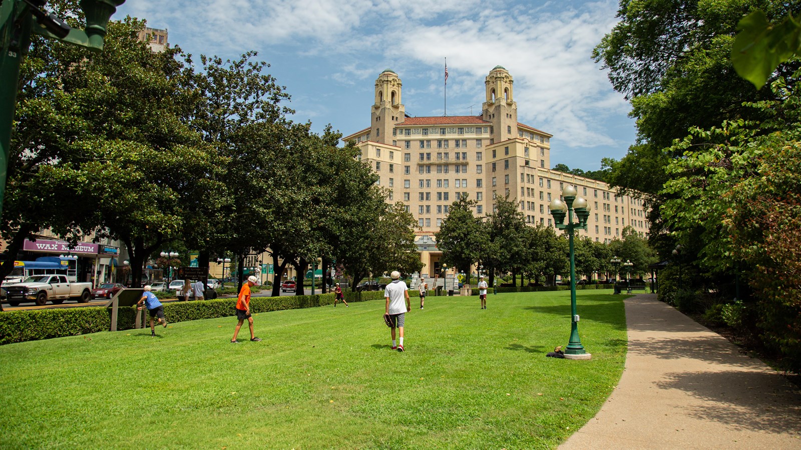 A group of young boys practice catching baseballs on the green lawn.