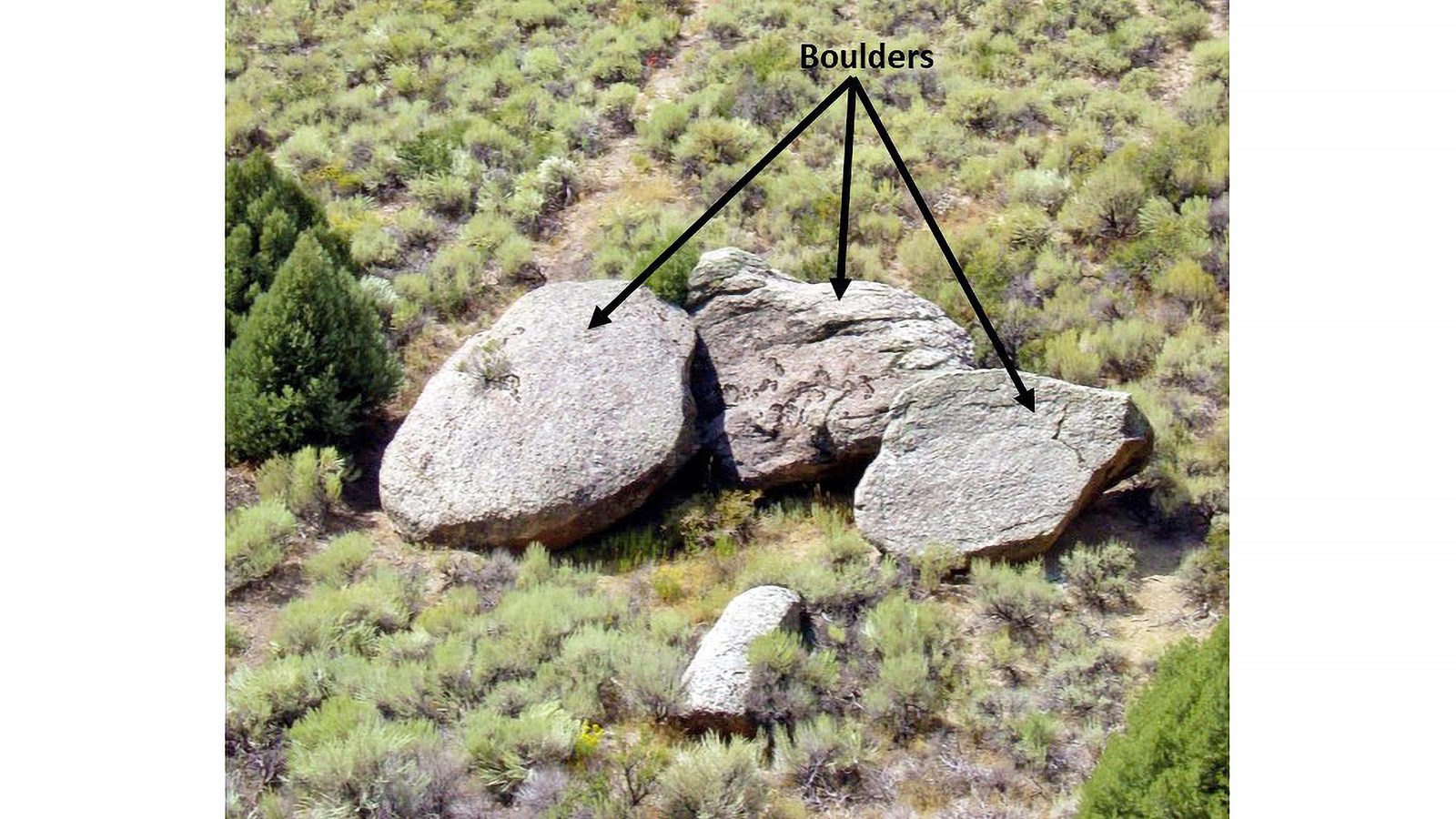 Granite boulders in a field of sage brush.