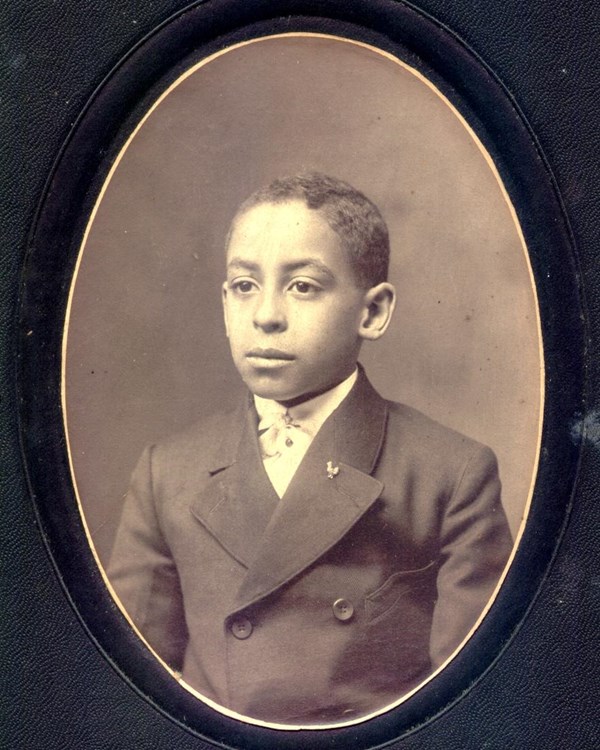 Melvin Walker, as a child, in a dress jacket sitting for a portrait