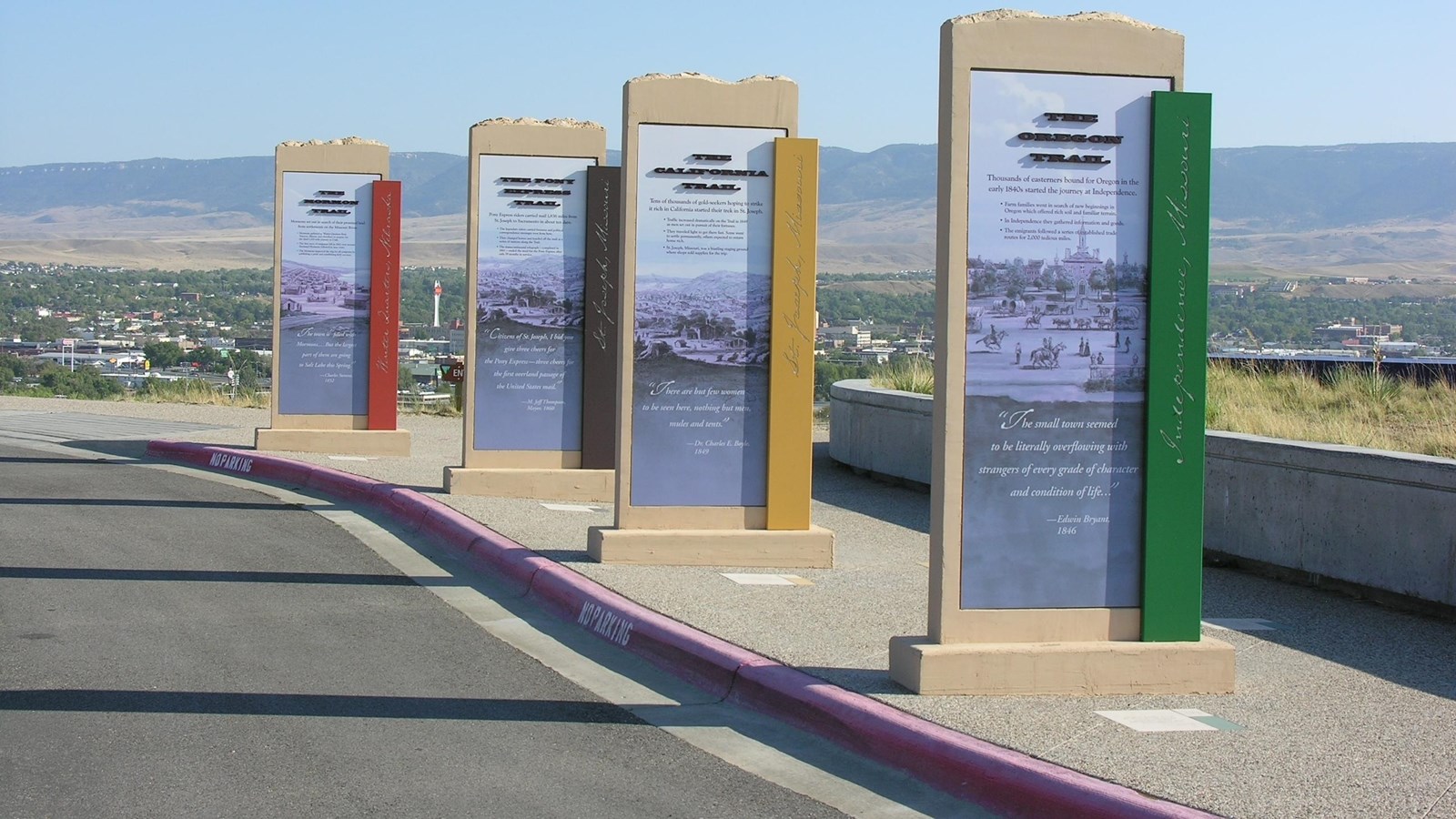 Large upright signs standing in a row in a parking lot.