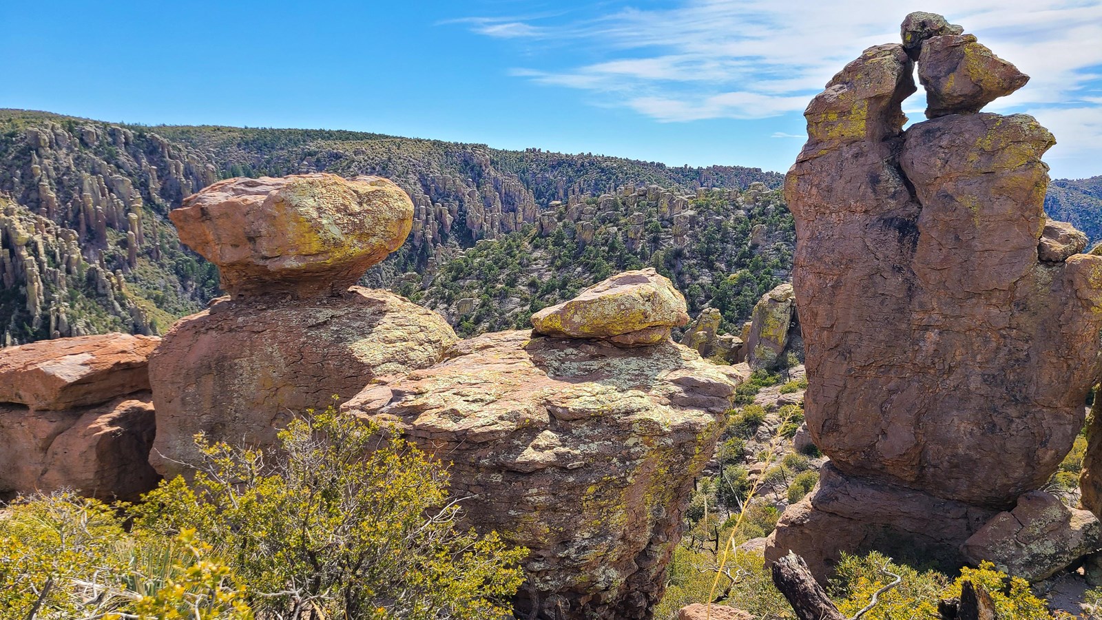 large rocks balance on narrow bases with valley behind