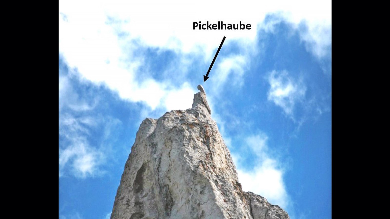 A spike-like protuberance on top of a granite pinnacle.